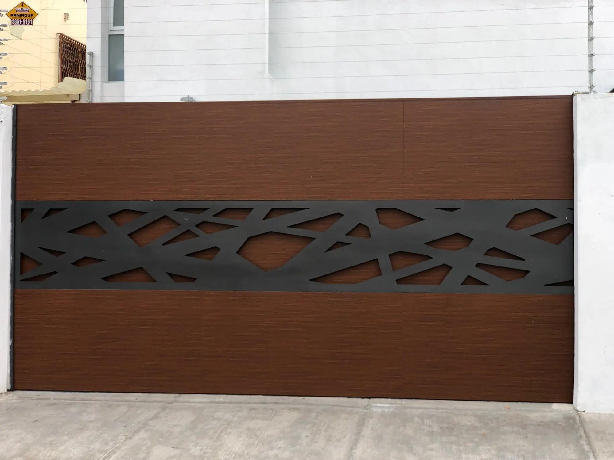 Portón corredizo de madera con celosía decorativa recortada