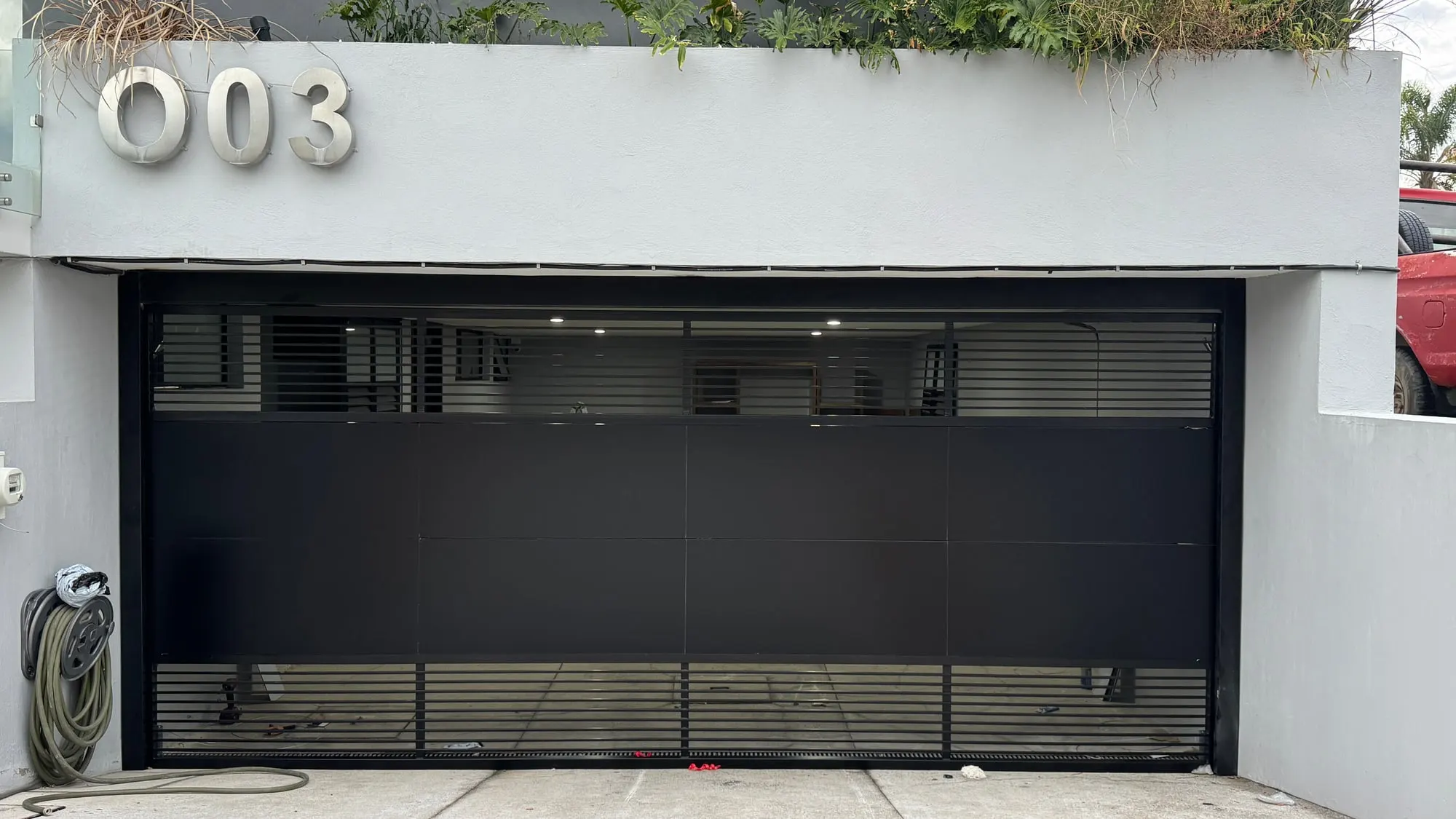 Acceso corredizo automatizado con celosía metálica y puerta peatonal integrada, instalado por Portalum en Guadalajara