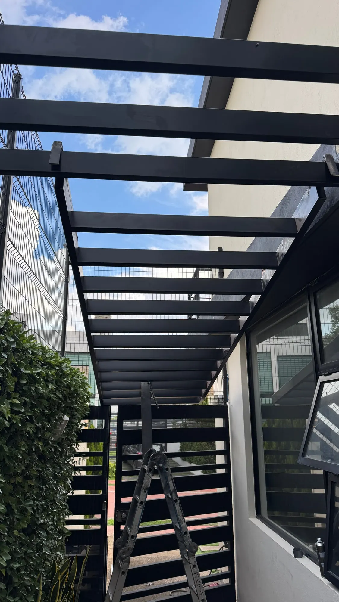 Pérgola metálica sobre terraza residencial