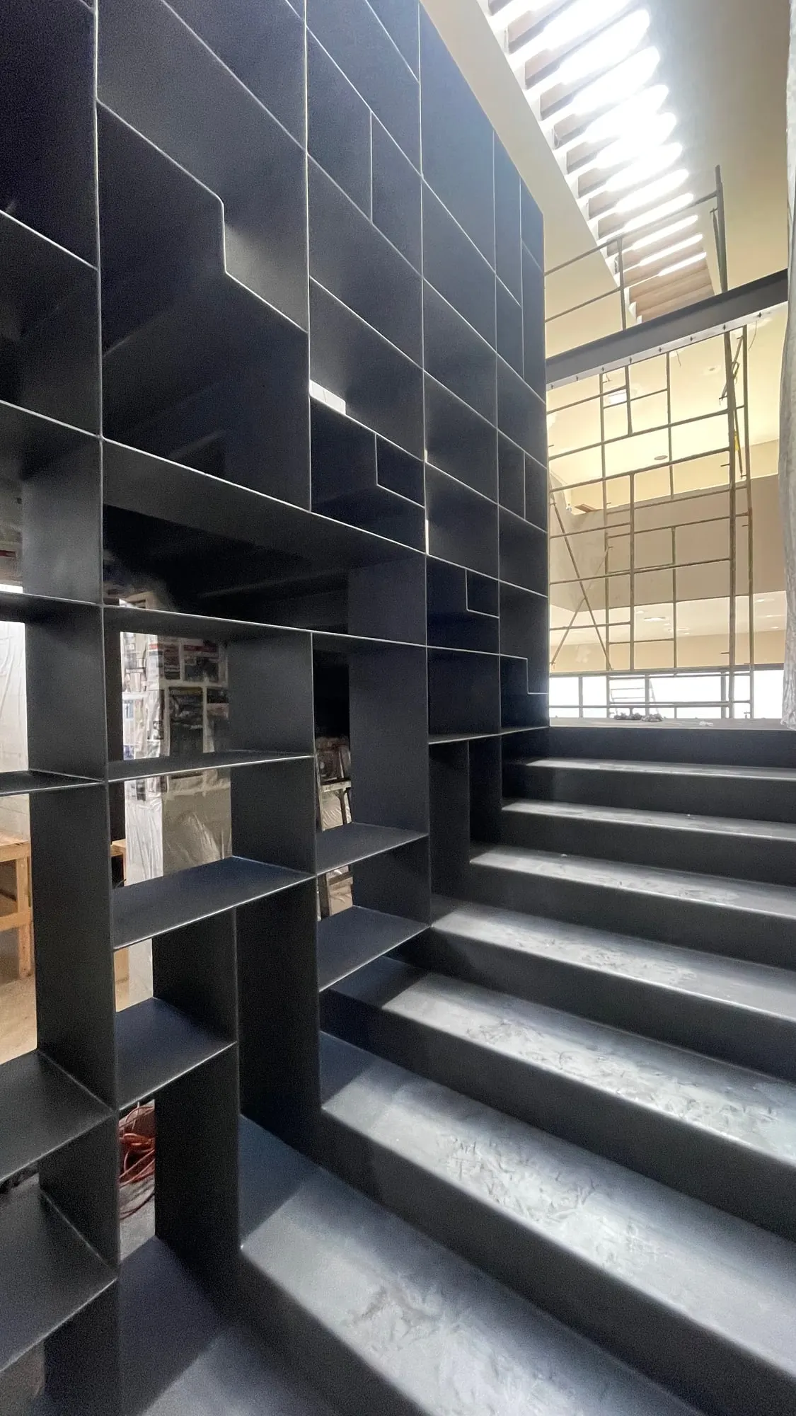 Escalera y librero de herrería negra en interior
