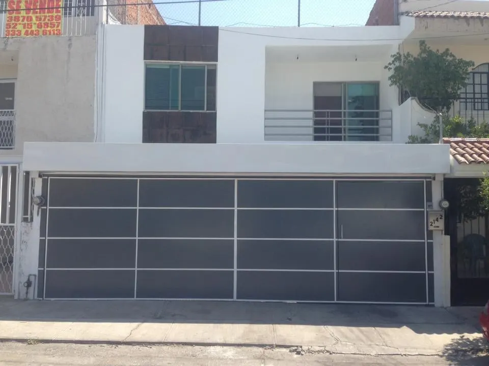 Portón plegadizo con marco metálico y paneles de vidrio